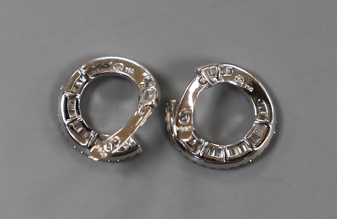 A modern pair of 750 white metal, round brilliant and graduated baguette cut diamond set open work circular earrings, 17mm, gross weight 6.6 grams